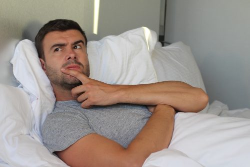 Man thinking in bed