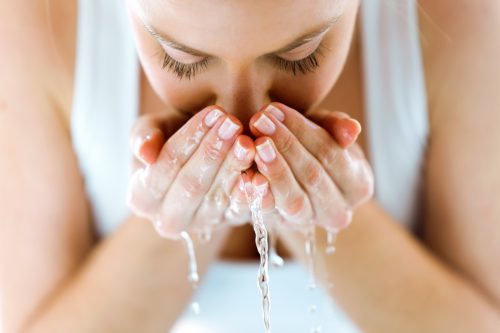Woman splashing water on face