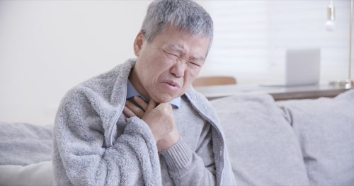 Older Man Clutching at Throat