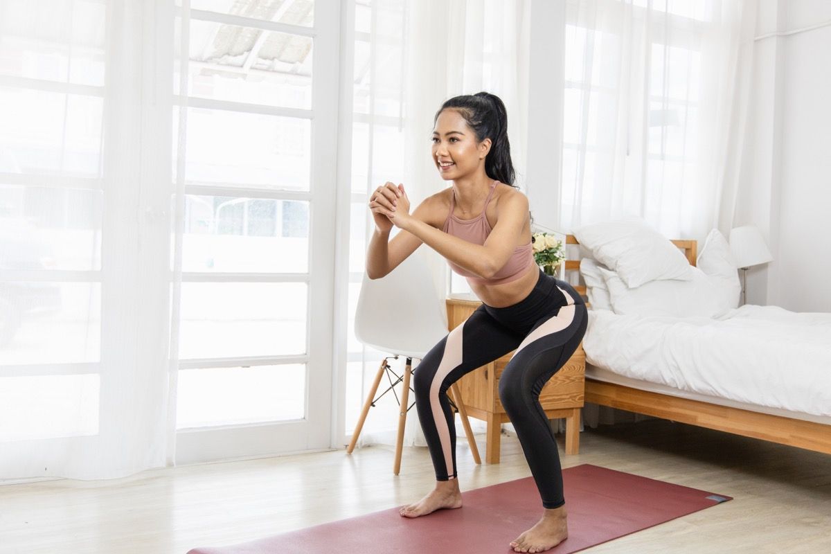 Mujer haciendo sentadillas con peso corporal