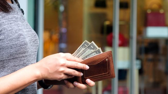 woman with dollar bills in wallet