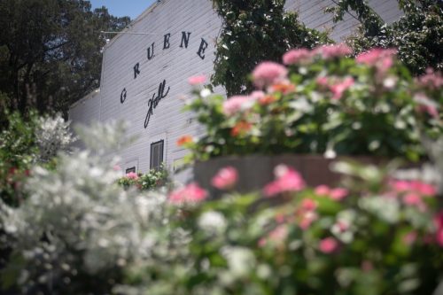 A white music hall surrounded by pink flowers