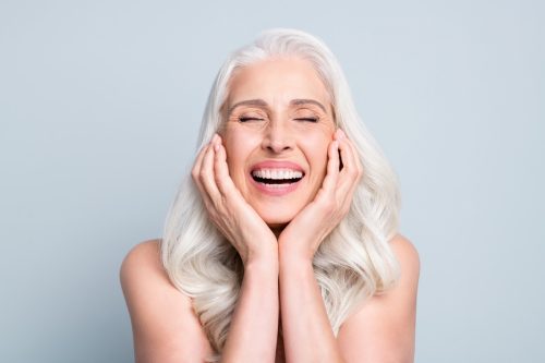 Woman with gray hair laughing.