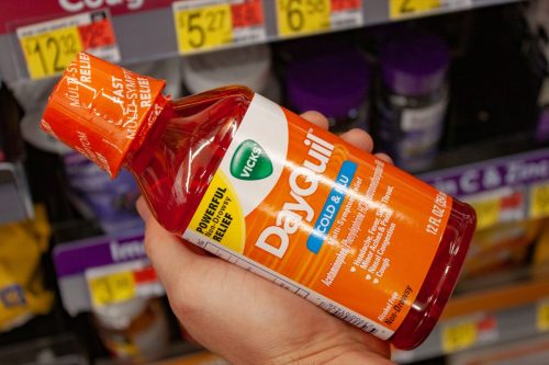 Person Holding Bottle of Dayquil