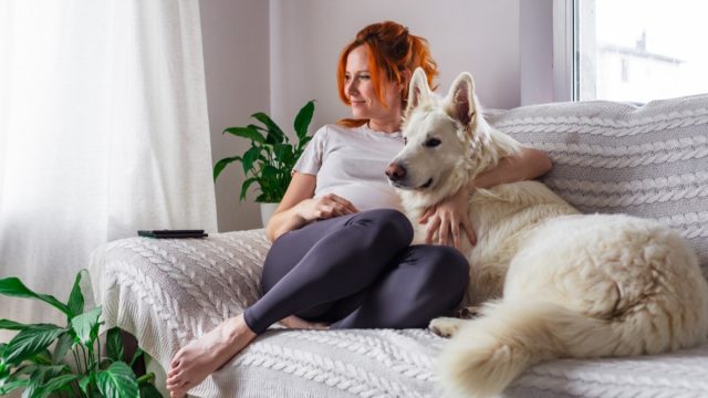 woman at peace with dog on couch