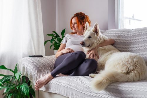 woman at peace with dog on couch