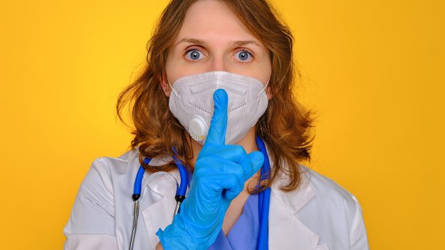 Woman,Nurse,In,A,Medical,Mask,Put,A,Finger,To