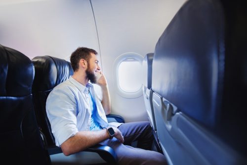 man on plane with empty seat next to him