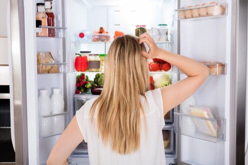 Person Contemplating in Front of Fridge