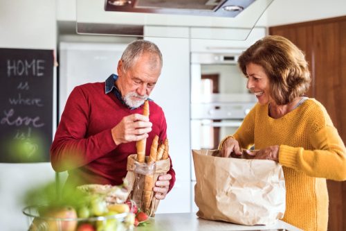 Elderly people are unpacking food in the kitchen