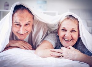 Older Couple Smiling Under the Covers