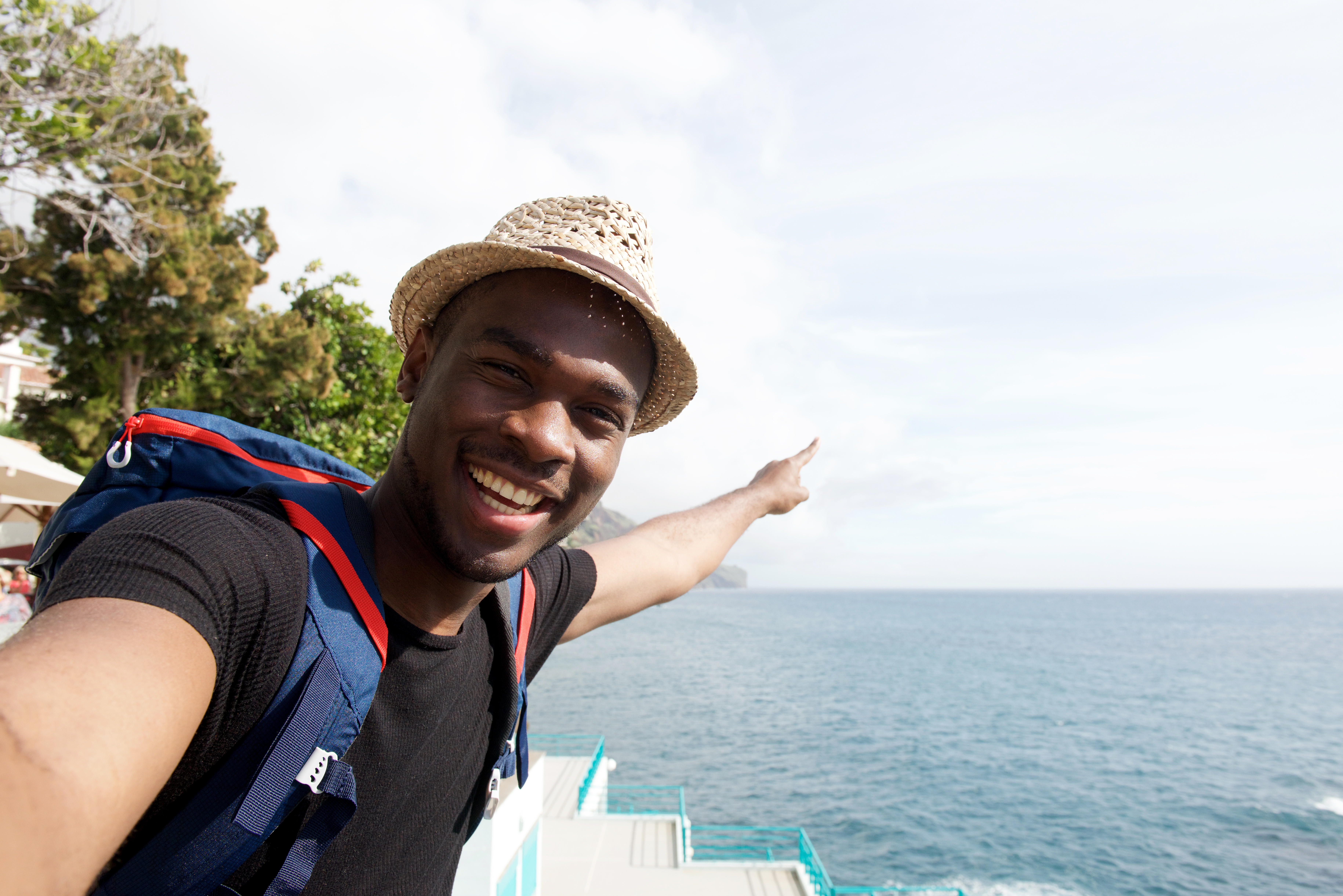 man taking selfie while on vacation in front of ocean