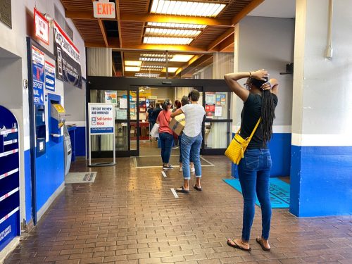 People waiting in line at a United States Post Office in Orlando, Florida where people are wearing face masks and social distancing,