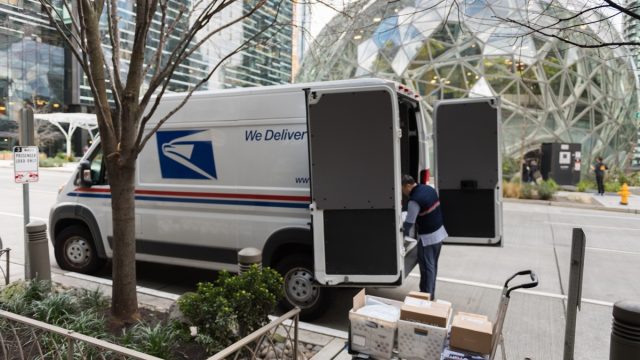 A USPS truck as a driver delivers packages on 6th avenue across from the Amazon Spheres in downtown late in the day.