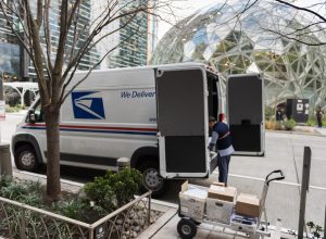 A USPS truck as a driver delivers packages on 6th avenue across from the Amazon Spheres in downtown late in the day.