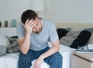 Restless man waking up early with headache after rough night