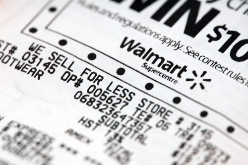 Walmart superstore receipt close-up featuring "we sell for less" slogan