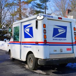 Winter view of a delivery truck from the United States Postal Service (USPS) on the street in New Jersey, United States after a snowfall.