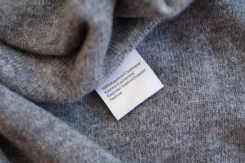 Close up of a gray sweater with a 100-percent cashmere tag.