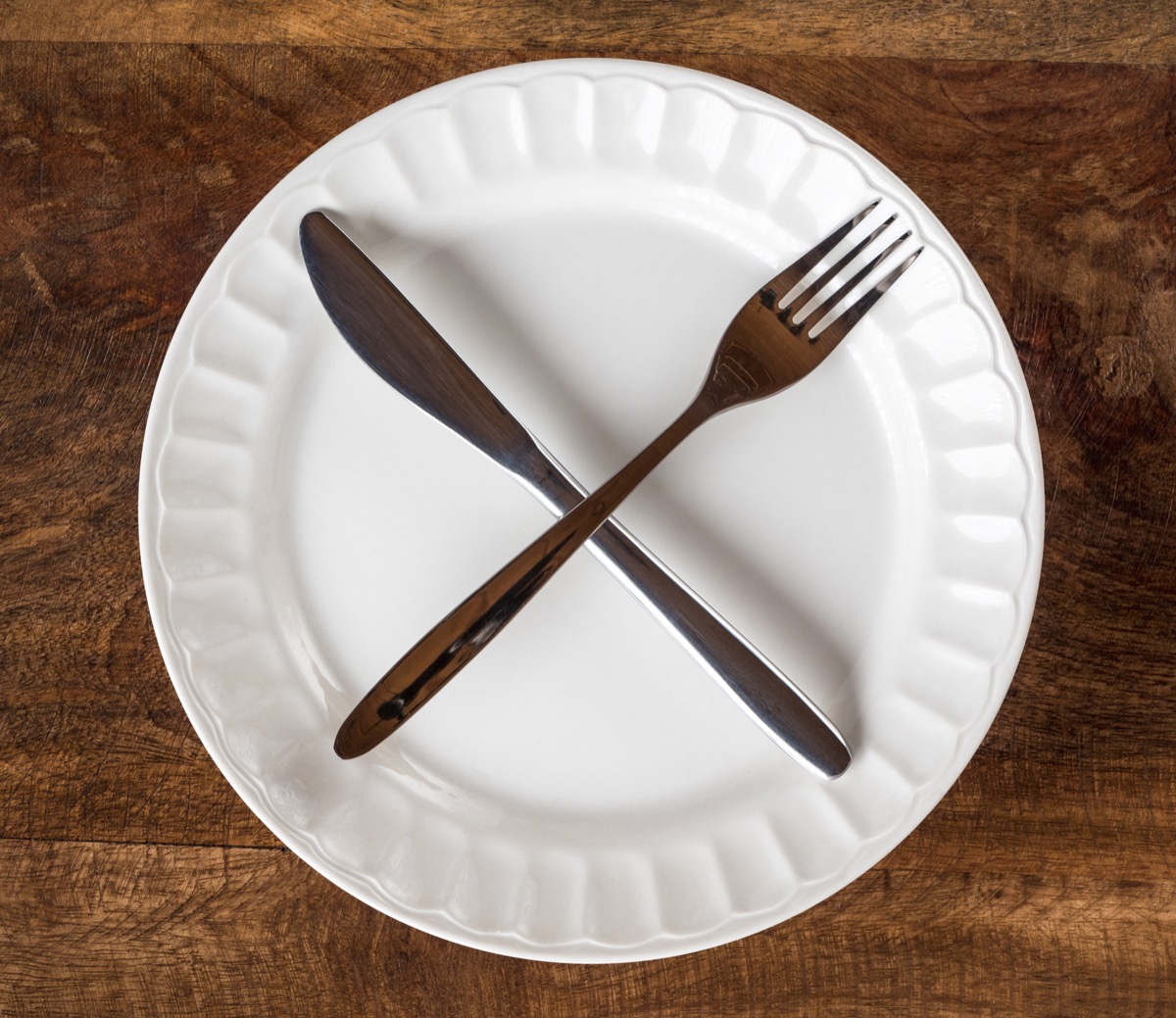 Fork and Knife forming an X on an empty white Plate