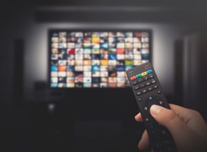 Watching a tv show with a remote controller.