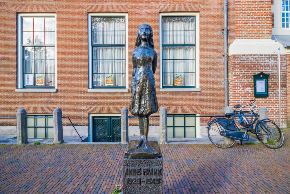A statue sitting in front of the Anne Frank House in Amsterdam
