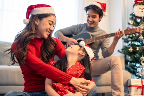 young asian family singing christmas music together