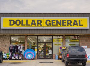 The front of a Dollar General store with a black SUV parked in front.