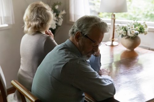 Elderly couple looking away from eachother, not in love. 