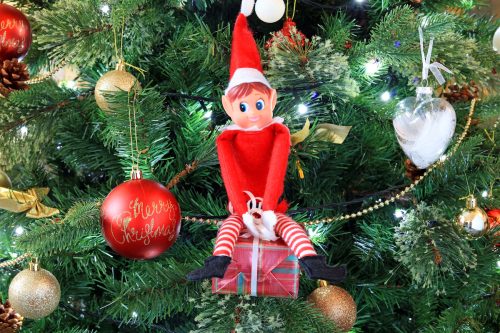 An elf ornament on a Christmas tree.