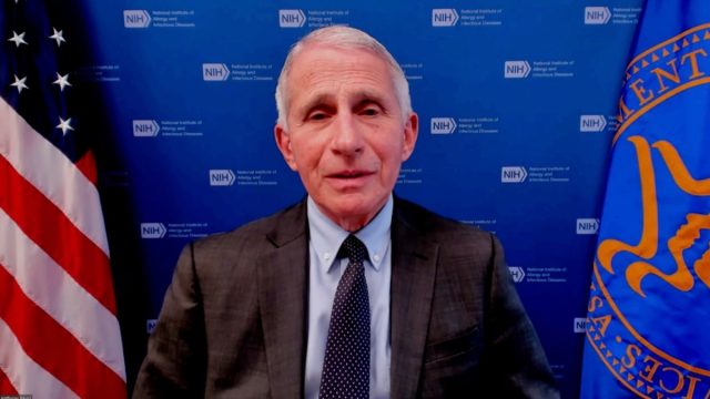 Dr. Anthony Fauci giving an interview on camera with a blue background