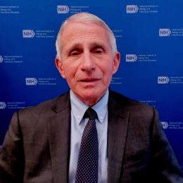 Dr. Anthony Fauci giving an interview on camera with a blue background