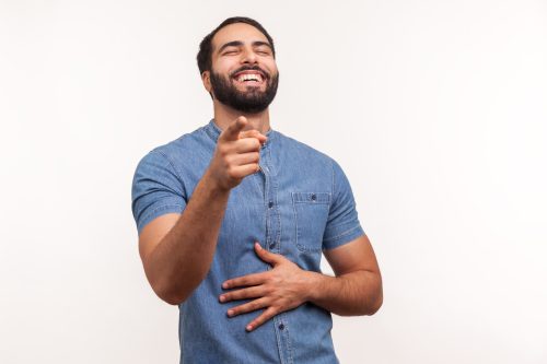 man holding his stomach while laughing
