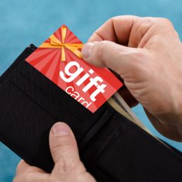 A closeup of a hand removing a gift card from a wallet