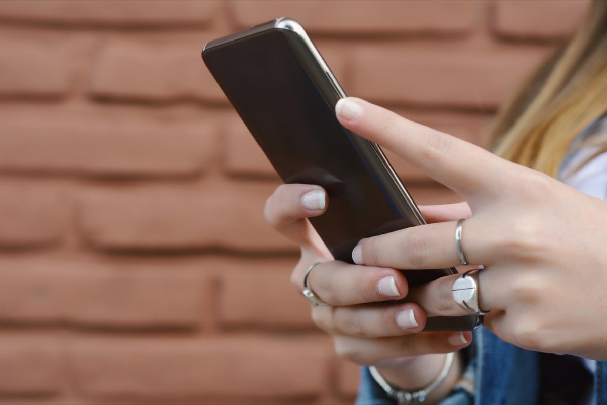 woman with pink nails on her phone.