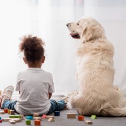 little girl sitting with her dog