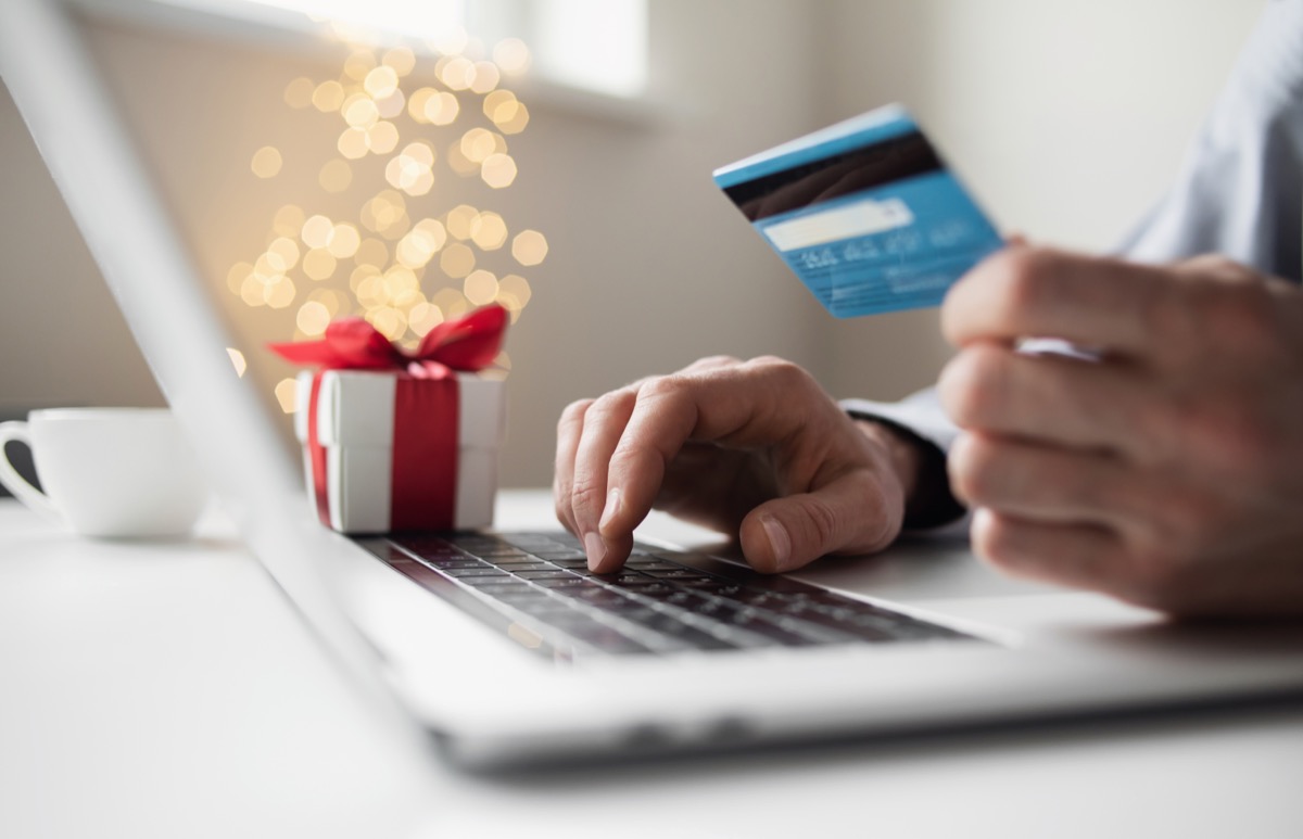 Shopping online during holidays. Man using laptop computer and credit card, ordering Christmas gifts. Shopping, internet banking, store online, payment, surprise, spending money, holidays concept