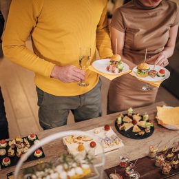 Close up of young people sampling appetizers at a holiday party.