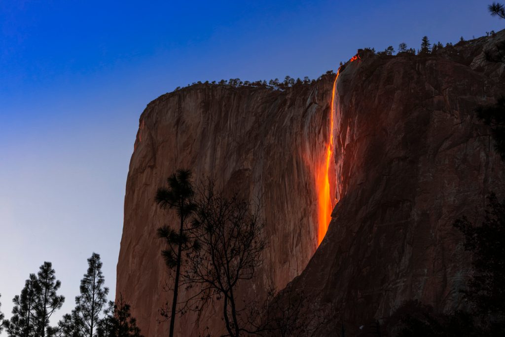 A view of Horsetail Waterfall in Yosemite glowing due to firefall