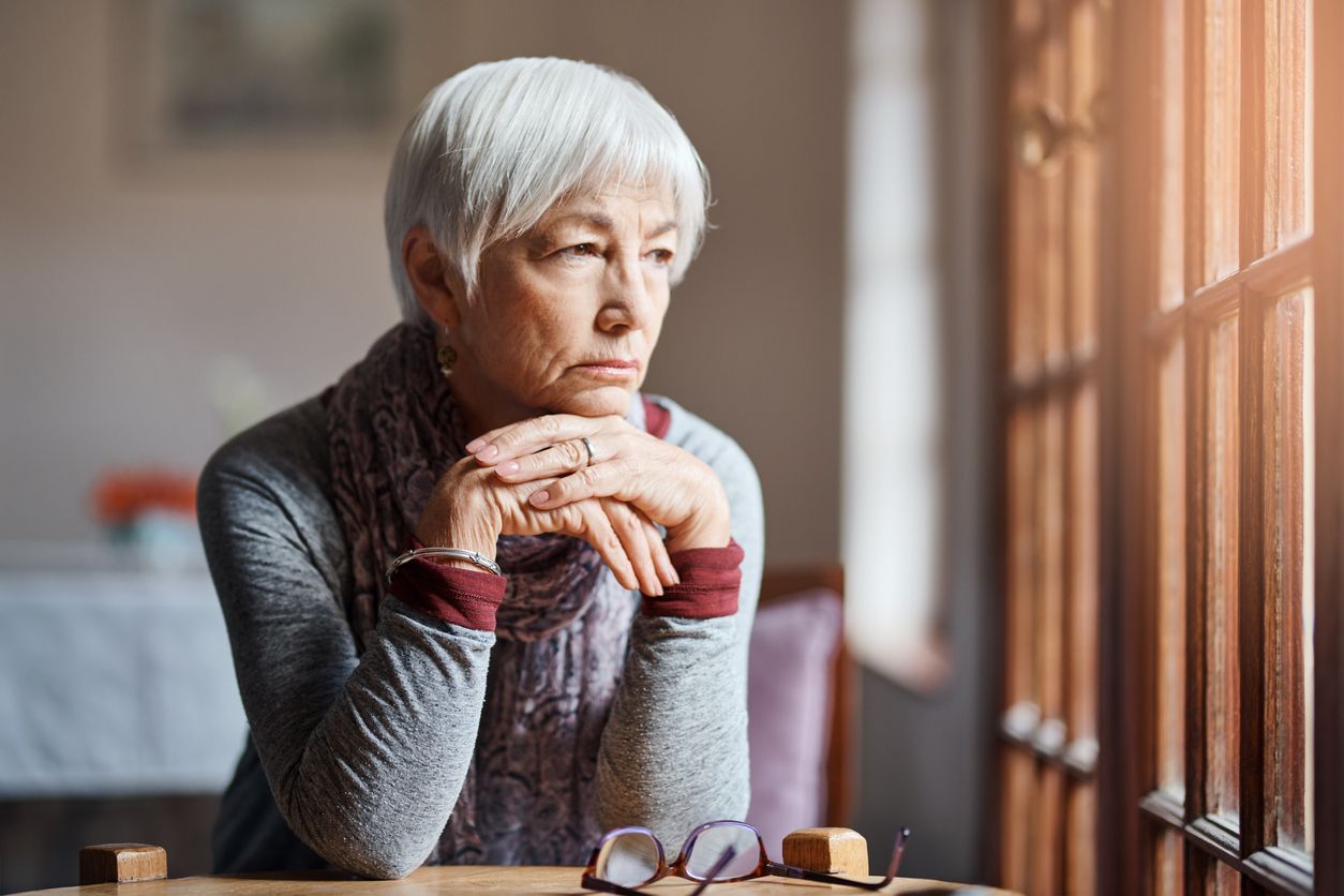 Senior woman sitting and looking concerned.