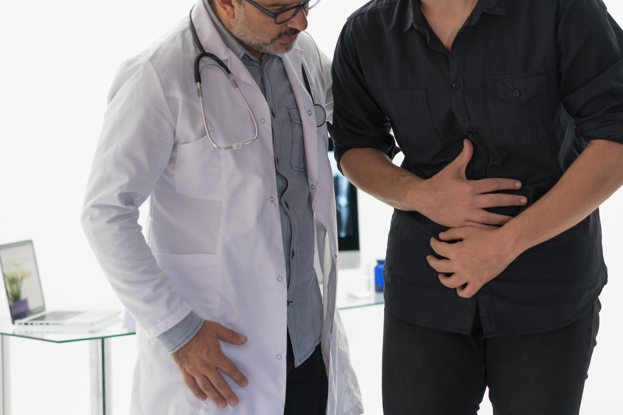 Doctor talking to patient with stomach pain.