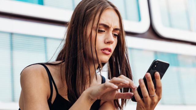 Worried Woman Checking Messages on Smart Phone