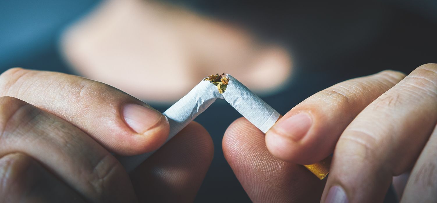 Hands breaking a cigarette in half