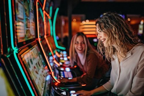 Girl friends gambling in casino on slot machine 