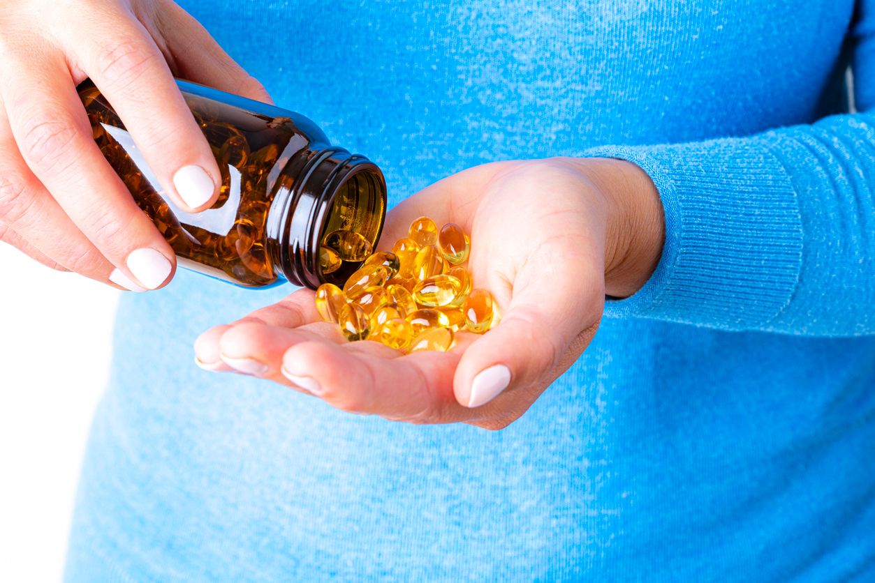 Capsules in bottle being poured into hand.