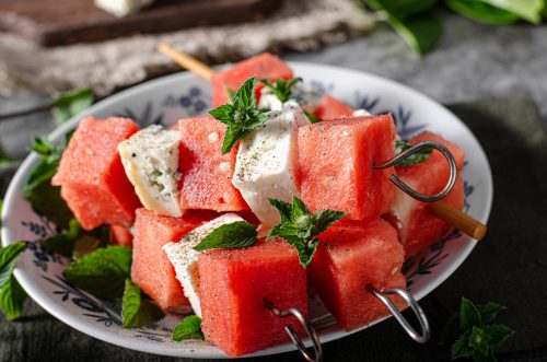Fresh melon with feta and blue cheese, topped with herbs