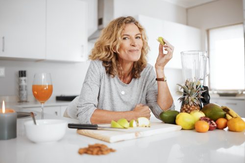 Woman eating a healthy meal in the kitchen.