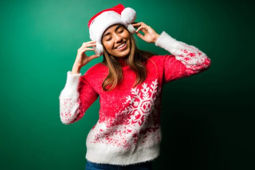 young woman smiling and listening to christmas music