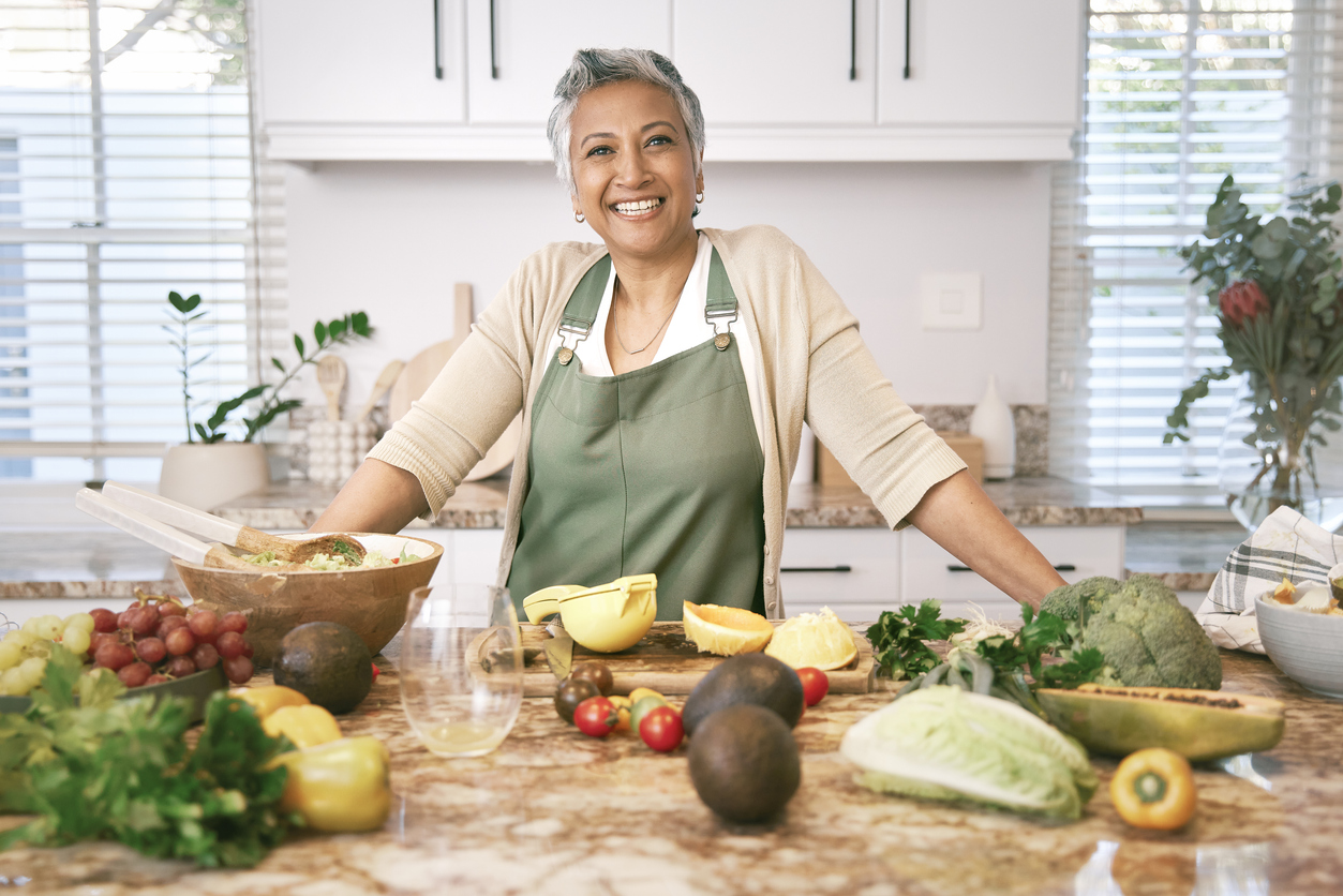 Woman standing in the kitchen preparing healthy food.
