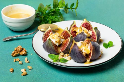 Ripe figs stuffed with cream cheese with honey sauce and walnuts. 
